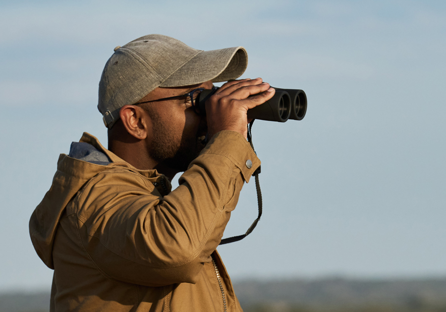 A young man looking through binoculars